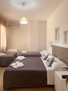 a bedroom with two beds with towels on them at Hotel Elios Tao in Taormina