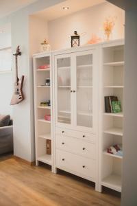 a white cabinet with glass doors in a room at Cosy Seaside Apartment in Liepāja