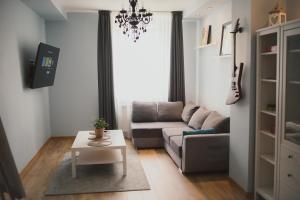 uma sala de estar com um sofá e uma mesa em Cosy Seaside Apartment em Liepāja