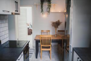 a kitchen with a wooden table and a dining room at Cosy Seaside Apartment in Liepāja