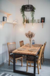 stół jadalny z krzesłami i wazon kwiatów w obiekcie Cosy Seaside Apartment w mieście Lipawa