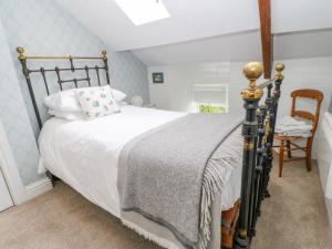 a bedroom with a bed and a chair at Lavender Cottage in Bishop Auckland
