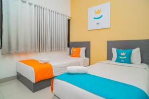 Ein Bett oder Betten in einem Zimmer der Unterkunft Sans Hotel Widarasari Cirebon