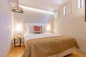 ein Schlafzimmer mit einem Bett in einem weißen Zimmer in der Unterkunft My homey at Flores in Porto
