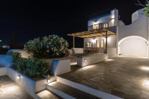Biały dom ze światłami w nocy w obiekcie Naxian Queen Luxury Villas & Suites w mieście Agia Anna (Naxos)