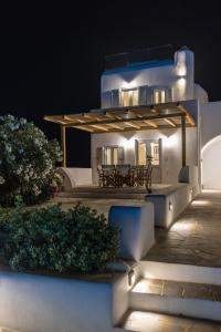 un edificio bianco con una panchina di fronte ad esso di notte di Naxian Queen Luxury Villas & Suites ad Agia Anna Naxos
