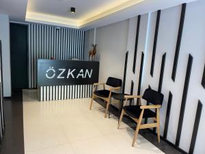 ウズンギョルにあるOzkan Otelの椅子2脚と壁の看板が備わる部屋