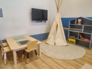 a toy room with a table and a play tent at Ditlin Apartmanok in Pápa
