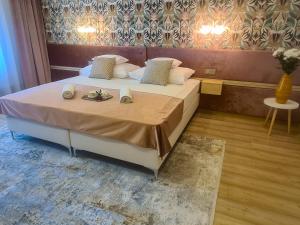 a bedroom with a bed with two plates of food on it at Ditlin Apartmanok in Pápa