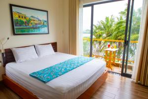 a bedroom with a bed and a large window at Coral Riverside Homestay & Hostel in Hoi An