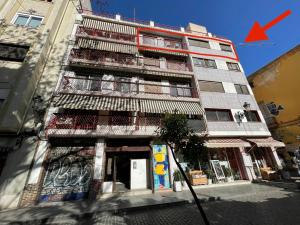 a tall building with a red arrow on it at Plaza Del Carmen in Valencia