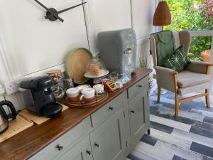 - un comptoir de cuisine avec une cafetière et une chaise dans l'établissement The Peels B&B, à Lowestoft