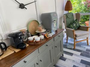 a kitchen counter with a coffee maker and a chair at The Peels B&B in Lowestoft