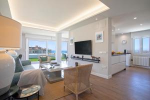 a living room with a couch and a tv at Genteel Home Elcano Terrace in Málaga +11 photos