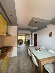 una cucina e una sala da pranzo con tavolo e sedie di Lovely 3 bedrooms Apartament a Oradea Altre 10 foto