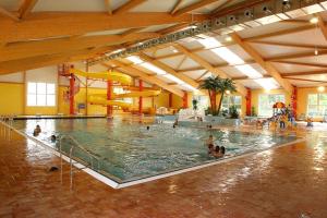 een groot zwembad met mensen in het water bij Sporthotel Neuruppin - Apartmenthaus mit Ferienwohnungen in Neuruppin