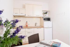 una cocina con armarios blancos y una mesa con un periódico en The Bastion of Hvar, en Hvar