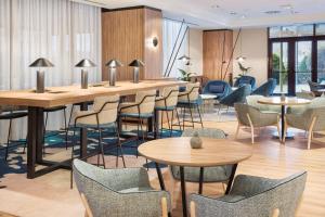 a waiting area with tables and chairs and tablesktop at Melia Avenida de America in Madrid