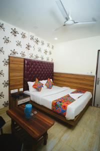 sypialnia z dużym łóżkiem z drewnianym zagłówkiem w obiekcie Hotel Delhi Darshan Deluxe-By RSL Hospitality w Nowym Delhi
