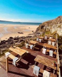 a deck with tables and chairs on the beach at Unique 4bed large central Hayle cottage nr St Ives in Hayle