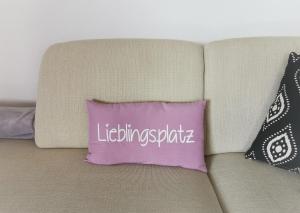 a purple pillow on a couch with the words volunteering sparta at Ferienwohnung Falkenhof in Lindlar