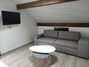 a living room with a couch and a table at La clé du Champ in Le Clerjus