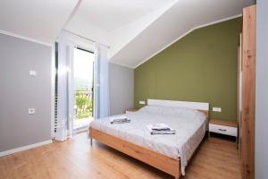 1 dormitorio con cama y ventana grande en Kuća za odmor Niko, en Mirlović Zagora