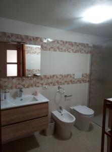 bagno con lavandino, servizi igienici e specchio di Al tegolaio a Pozzallo