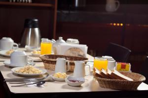 un tavolo con prodotti per la colazione e succo d'arancia sopra di Qosqo Wasi a Cuzco