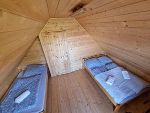 Cette chambre en bois offre une vue de tête sur deux lits. dans l'établissement Groniówka, à Buczkowice