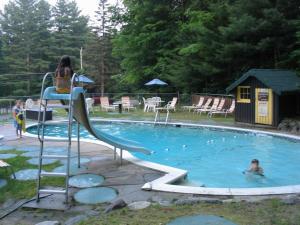 a woman sitting in a chair in a swimming pool at Amber Lantern One-Bedroom Cottage in Lake George