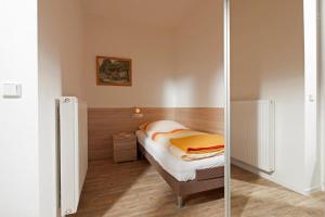 ein kleines Schlafzimmer mit einem Bett und einem Spiegel in der Unterkunft Ferienhaus Mien Huske in Norderney