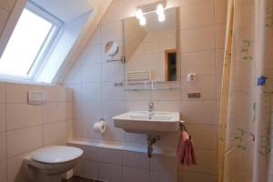 La salle de bains est pourvue d'un lavabo et de toilettes. dans l'établissement Ferienhaus Mien Huske, à Norderney