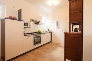 a kitchen with white appliances and wooden floors at Ferienhaus Mien Huske in Norderney