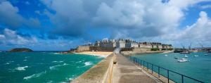 a view of a beach and a building with boats in the water at Le Bigorneau , beach at 20m and free private carpark in Saint Malo