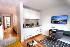 a kitchen with white cabinets and a table in a room at PREMIER SUITES Dublin, Ballsbridge in Dublin