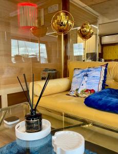 a living room with a yellow couch and a glass table at Hausboot mit Traumlage in Lübeck-Travemünde in Rönnau +37 photos