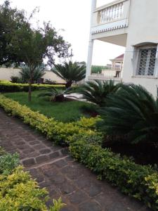 un sentiero in mattoni di fronte a una casa di MANOIR DES PRINCESSES BAFOUSSAM a Bafoussam