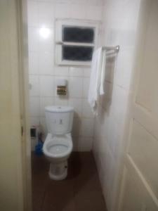 a bathroom with a white toilet and a window at MANOIR DES PRINCESSES BAFOUSSAM in Bafoussam