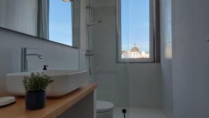 uma casa de banho branca com um lavatório e uma janela em Lujoso Apartamento en San Cristobal de la Laguna em La Laguna