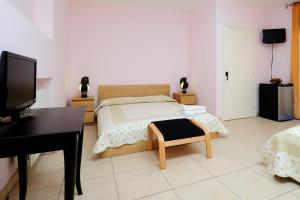 una camera con letto, scrivania e TV di Hotel Acquaplanet a Paterno