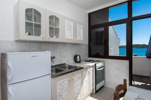 Una cocina con un refrigerador blanco y un fregadero. en Apartments Goran near the beach, en Srima