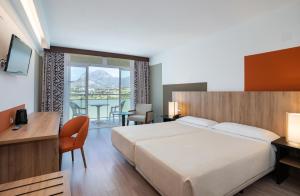 貝尼多姆的住宿－綠洲火烈鳥梅德普拉亞酒店，酒店客房设有一张床、一张书桌和一个阳台。