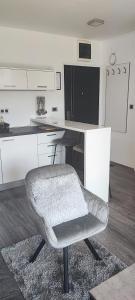 a white kitchen with a chair and a counter at Perfect Place 33 in Varaždin
