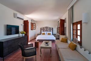 Habitación de hotel con cama y sofá en Maris Lindos Suites & Apartments en Líndos