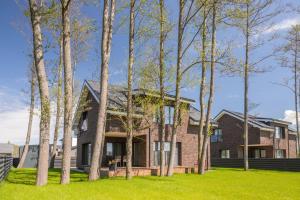 a house with trees in front of it at Vila „Perkūnas“ in Palanga