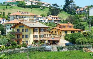 un grupo de casas en una colina con una señal en La Solana Montañesa en Comillas