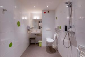 a bathroom with a shower and a toilet and a sink at Kyriad Lyon Est - Saint Bonnet De Mure in Saint-Bonnet-de-Mure
