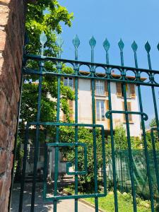 un cancello di metallo verde di fronte a un edificio di Casa di Aristide a Erba