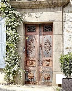 una antigua puerta de madera en el lateral de un edificio en L'oiseau Bleu suite MERLE BLEU, en Roubia